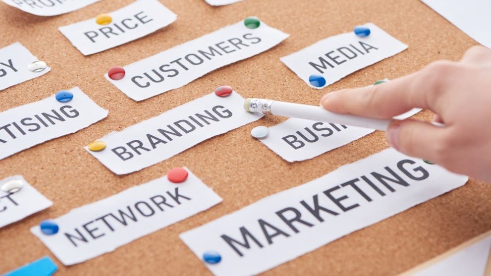 A businesswoman pointing to the branding strategy option on a board 