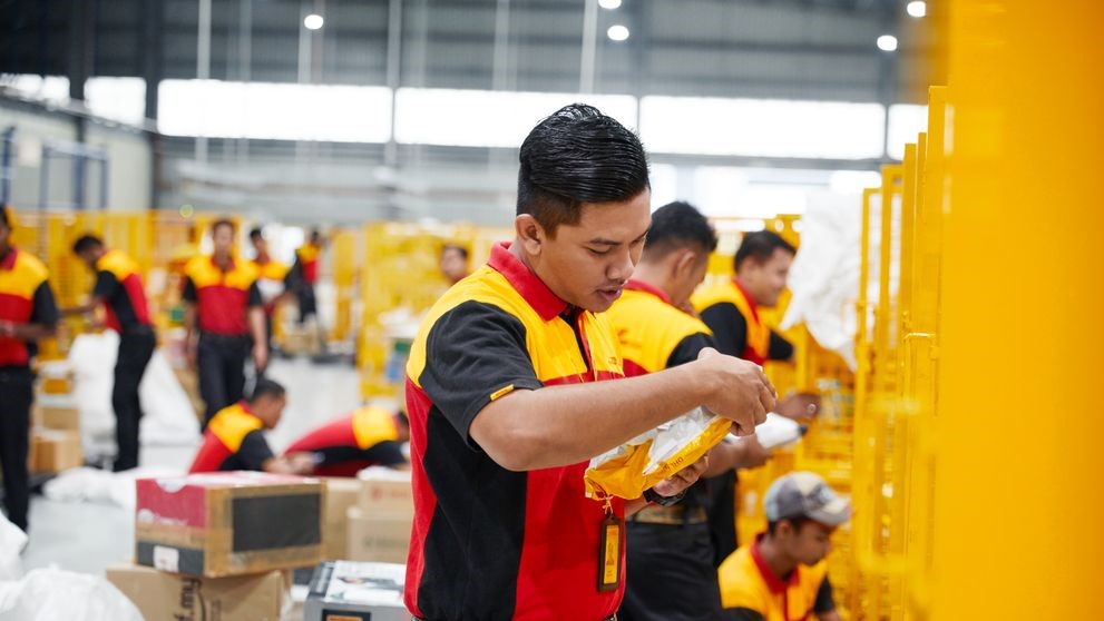 dhl express employee sorting parcel for supply chain efficiency