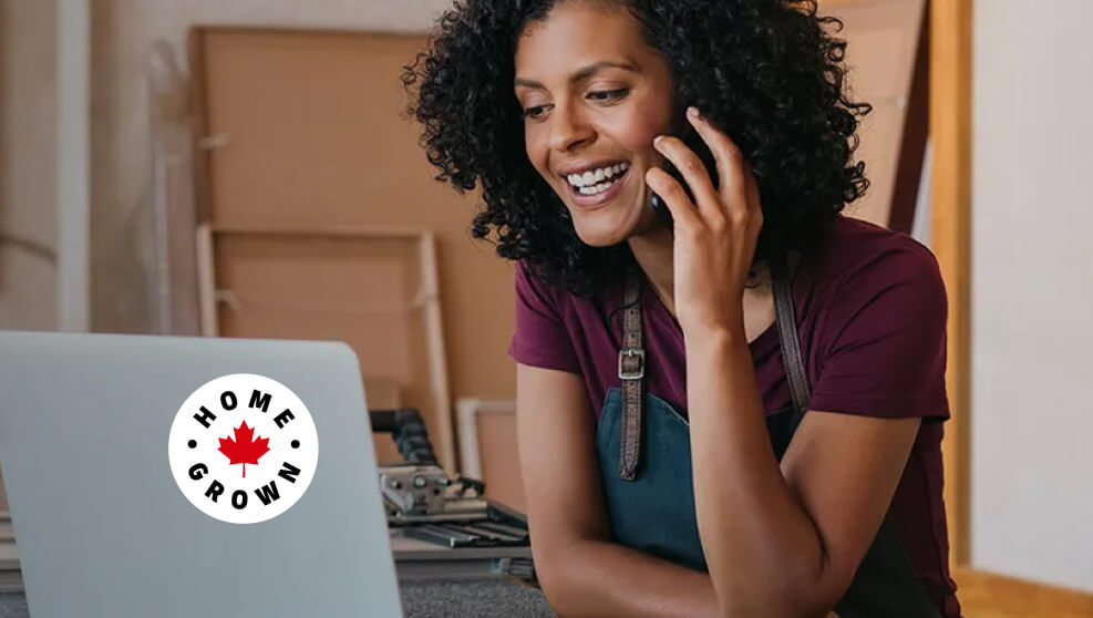 Woman talking on the phone while looking at her laptop
