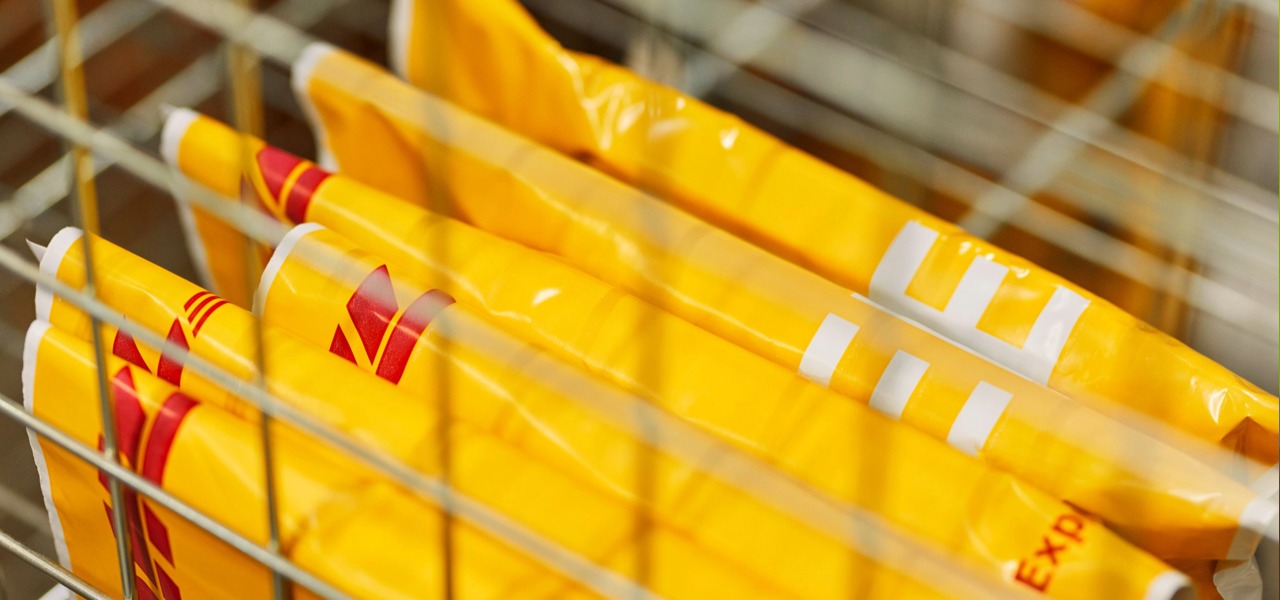 金属分拣框内整齐摆放 DHL 黄色快递防水胶袋