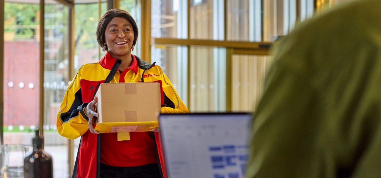 一名 DHL 员工在前台将包裹交付一位企业客户。