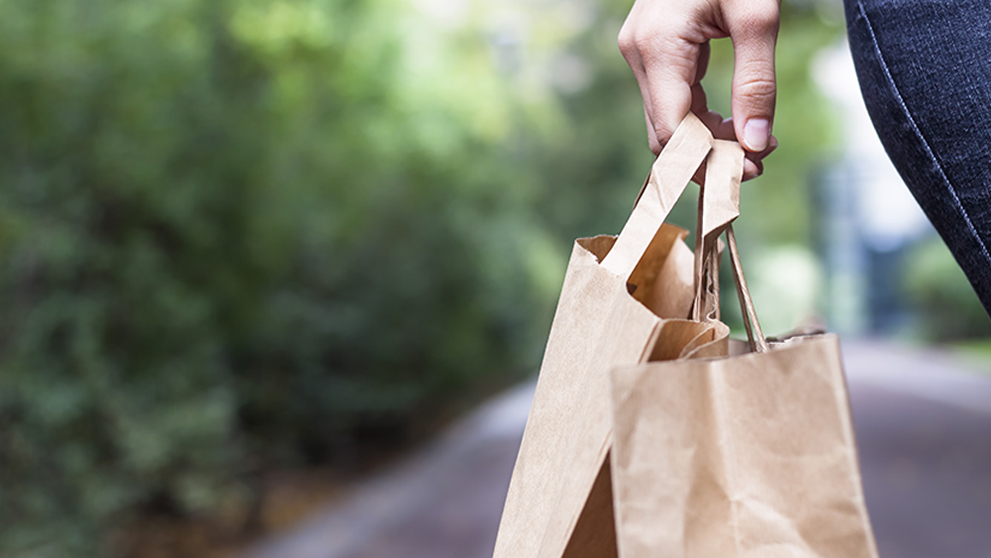 Girl doing ecological shopping with paper bags in hand