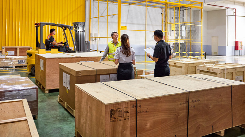 three people in a warehouse having a discussion
