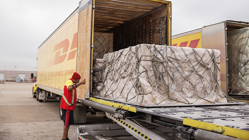 DHL employee directing the packing of a large pallet