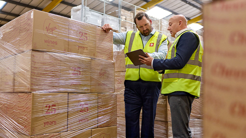 two men in hi vis looking at a tablet screen