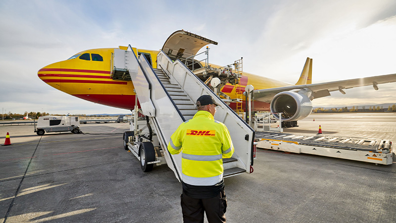 DHL employee standing in front of an aeroplane