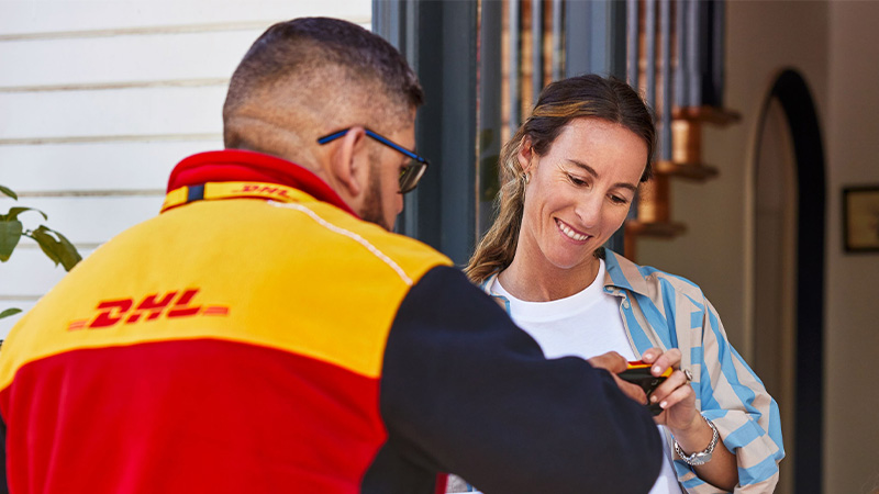 DHL courier delivering parcel to woman