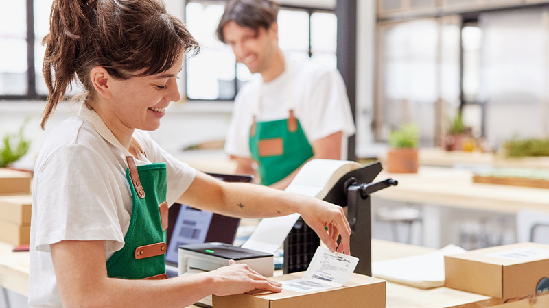 man and woman in green aprons smiling