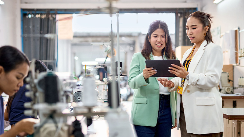 Two Asian women looking at tablet screen