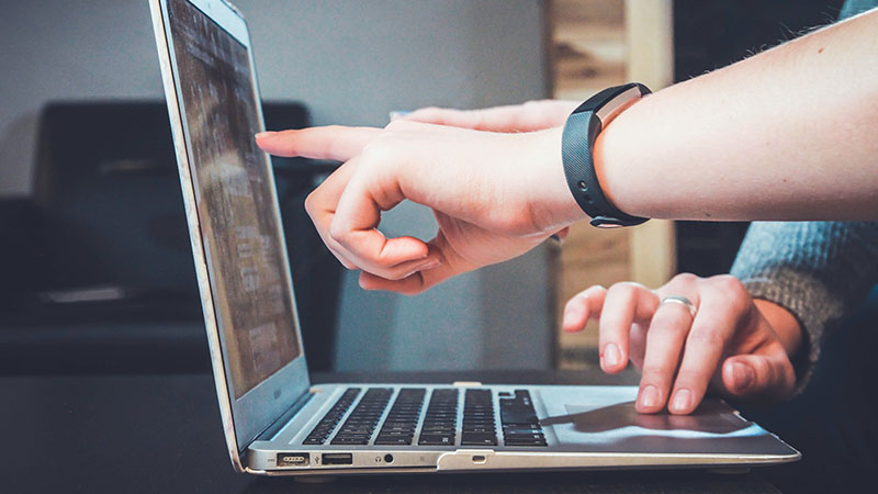 hands pointing at laptop screen