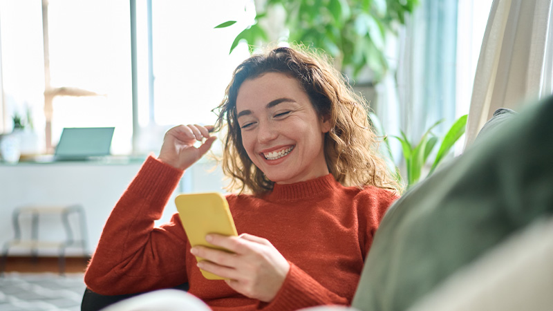 woman smiling at mobile phone screen