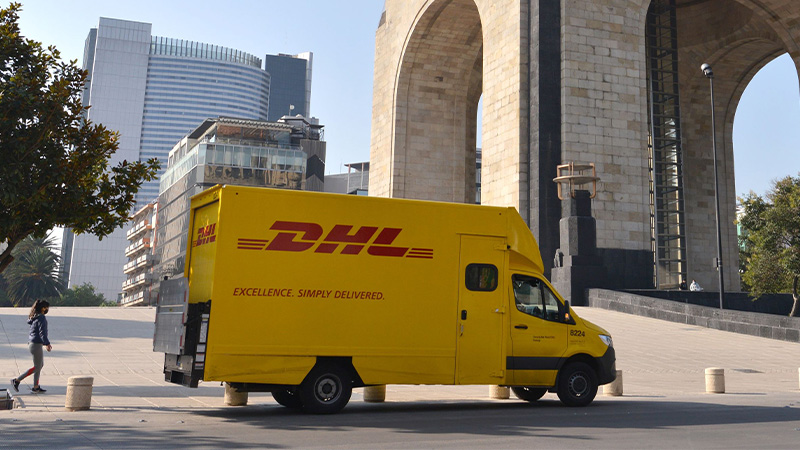 yellow DHL van besides a bridge