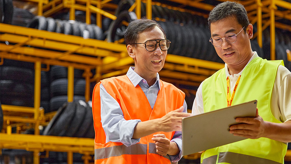 two Asian men looking at tablet screen
