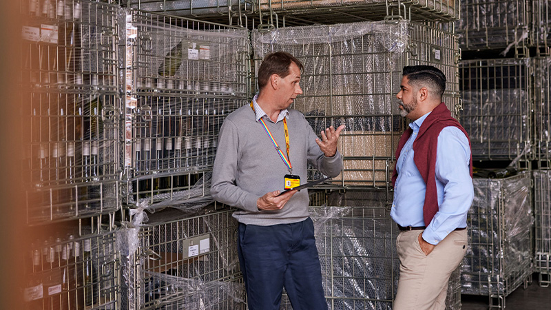 two men having a discussion in a warehouse