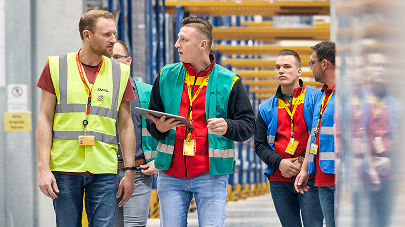 group of young persons in DHL uniform having a discussion
