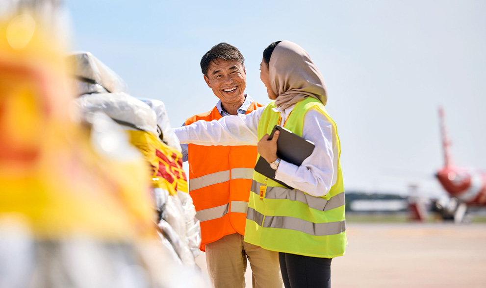 man and woman in headwrap smiling