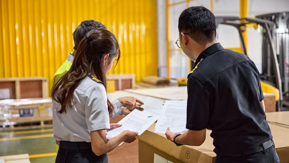 customs officer checking cargo inside dhl warehouse