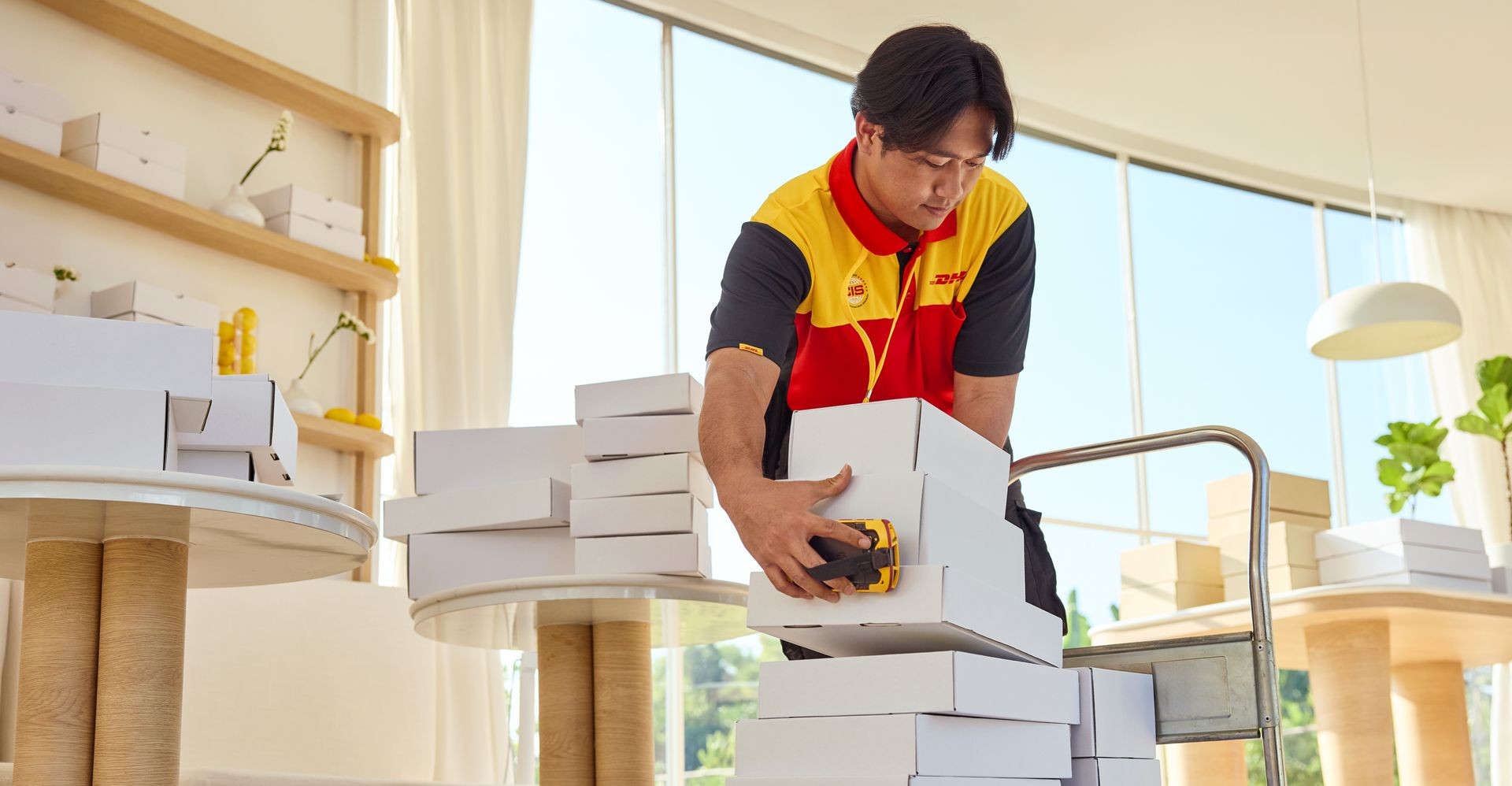 A DHL employee loads parcels for pickup on his handcart.