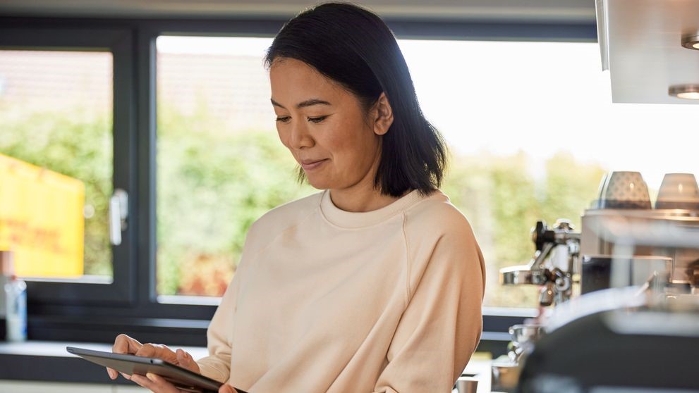 Seorang pemilik bisnis wanita menggunakan tablet untuk meneliti perjanjian perdagangan bebas di Indonesia
