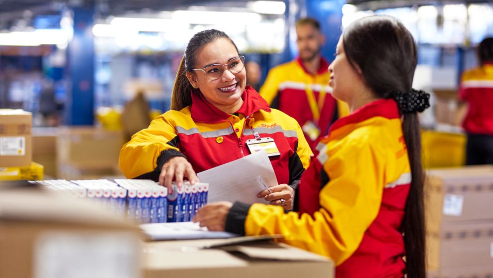 Karyawan DHL Express memeriksa barang dalam persiapan pengiriman internasional
