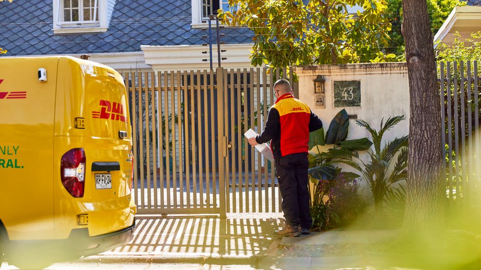 Agen pengiriman ekspres DHL menunggu untuk mengirimkan paket ke pelanggan