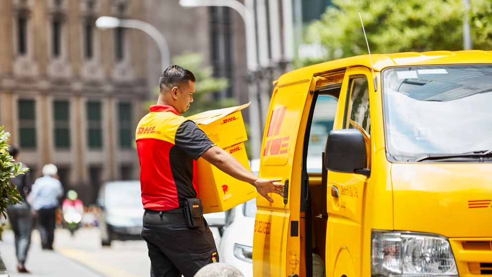 Karyawan DHL yang mengirimkan paket, mencerminkan pertumbuhan e-commerce