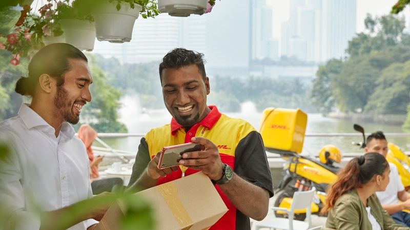 dhl courier standing outside an electric vehicle