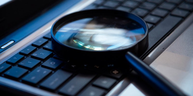 Magnifying glass on top of a keyboard