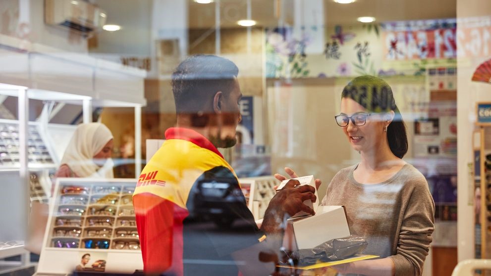 dhl express employee picking up parcel for international delivery