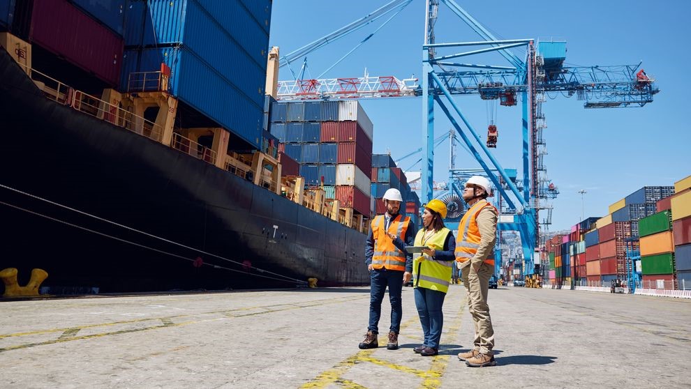 DHL employees at a large container shipyard overseeing shipments