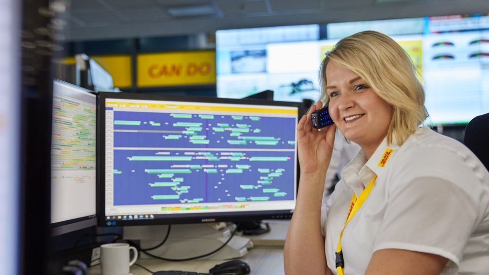 DHL employee sits at her desk and talks on the phone