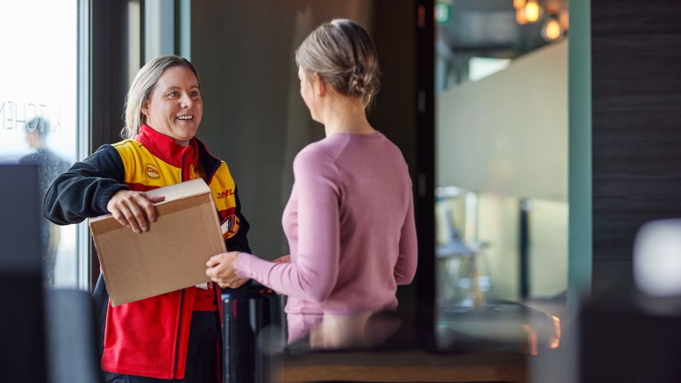 a dhl employee delivers a parcel to a customer