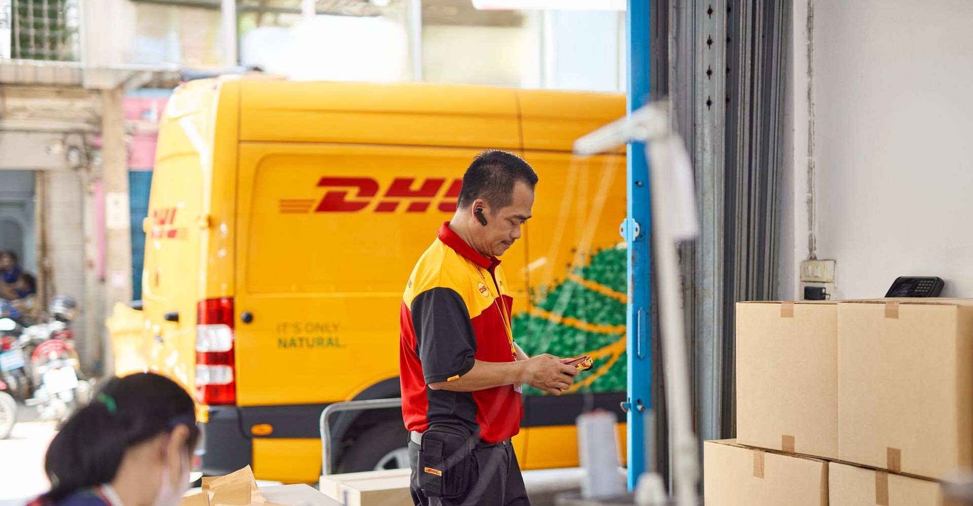 DHL Express employee picks up textiles in a store from the Philippines to be exported to the US