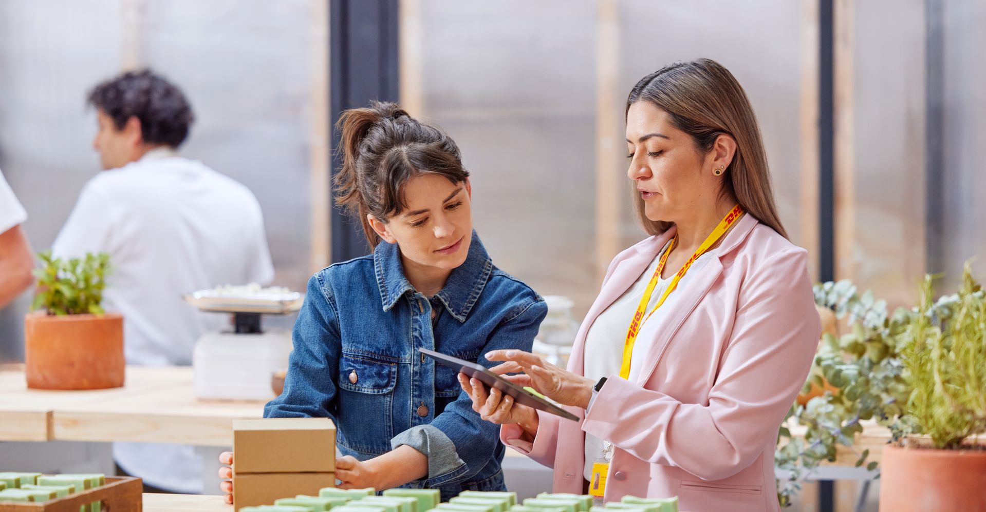 Business owner discussing sustainability strategy with DHL Express representative