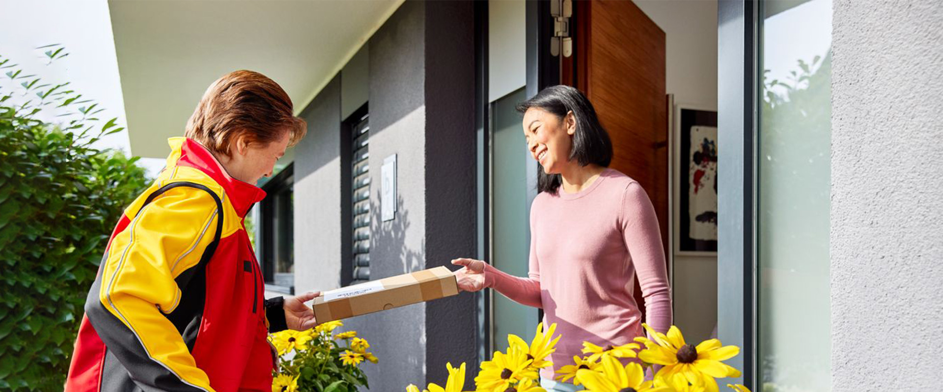 Female customer receiving a parcel from a female DHL courier