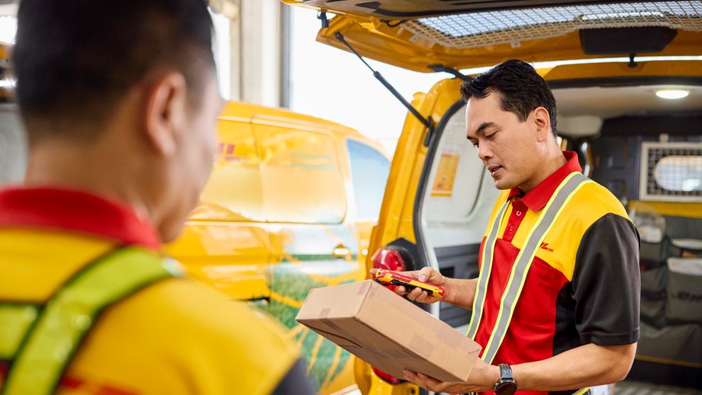 male DHL employee checking shipping label carefully