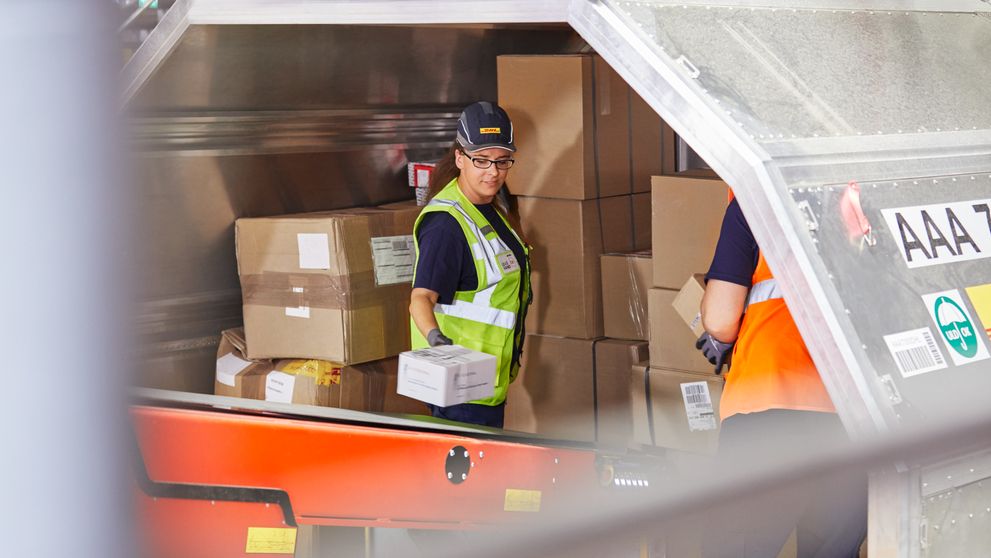dhl workers packing shipments by volumetric weight