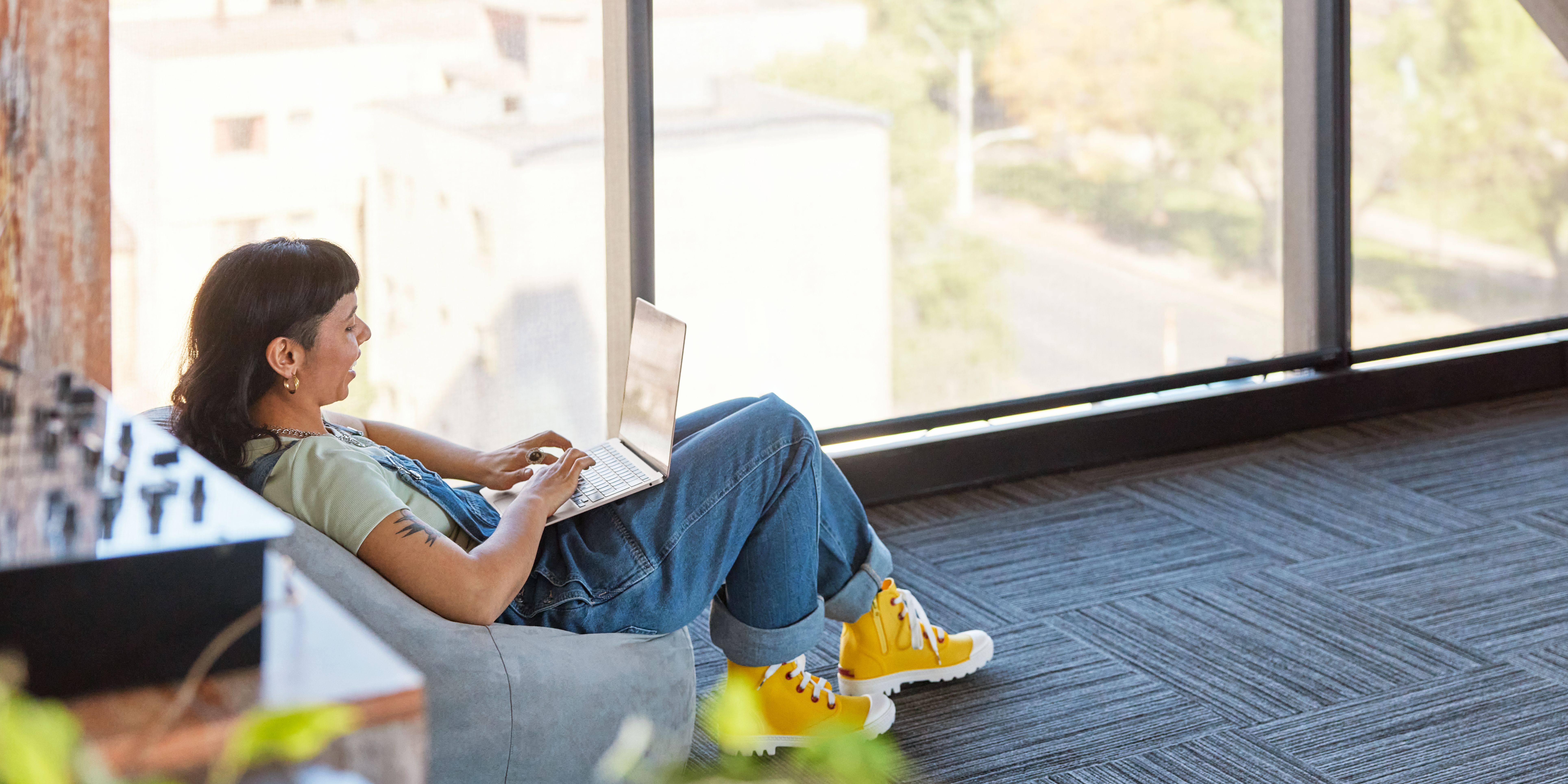 Young lady working on her laptop while sitting on the floor
