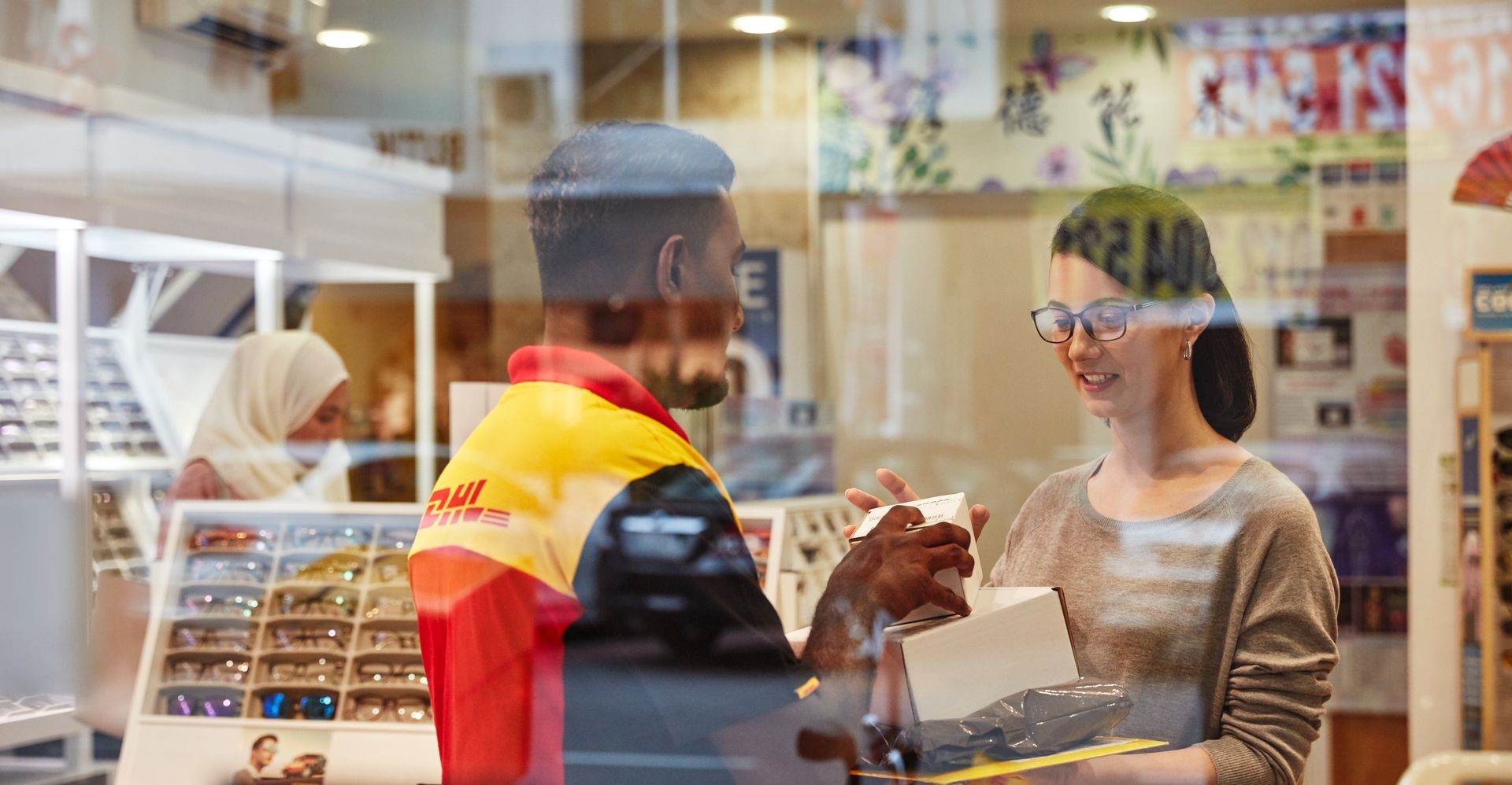  brand owner handing a packaging for shipping to a dhl express employee