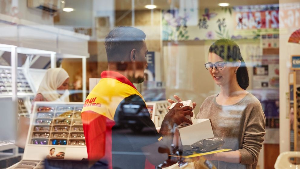  brand owner handing a packaging for shipping to a dhl express employee