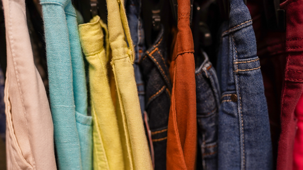 Clothes jeans on a hangers in the store second hand