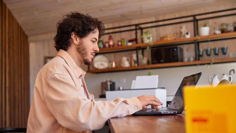A man using his laptop at home to complete the FDA registration