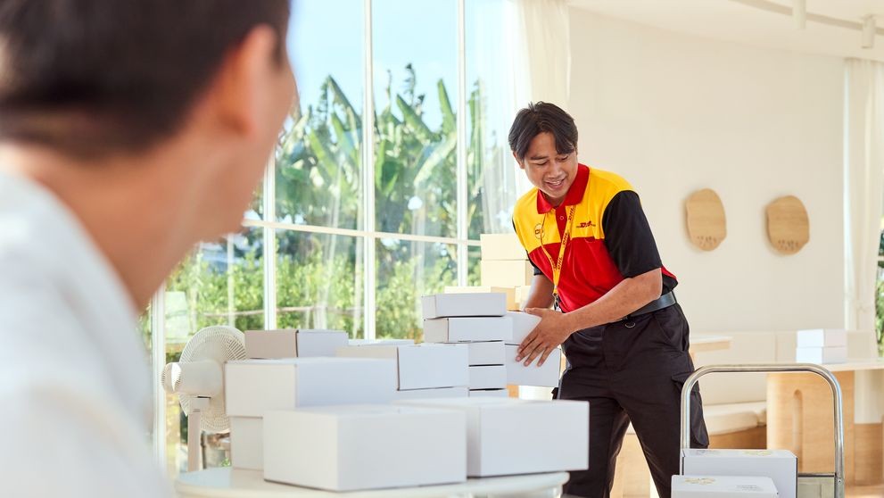 A male DHL Express employee loads parcels for pickup from an online business in Sri Lanka.