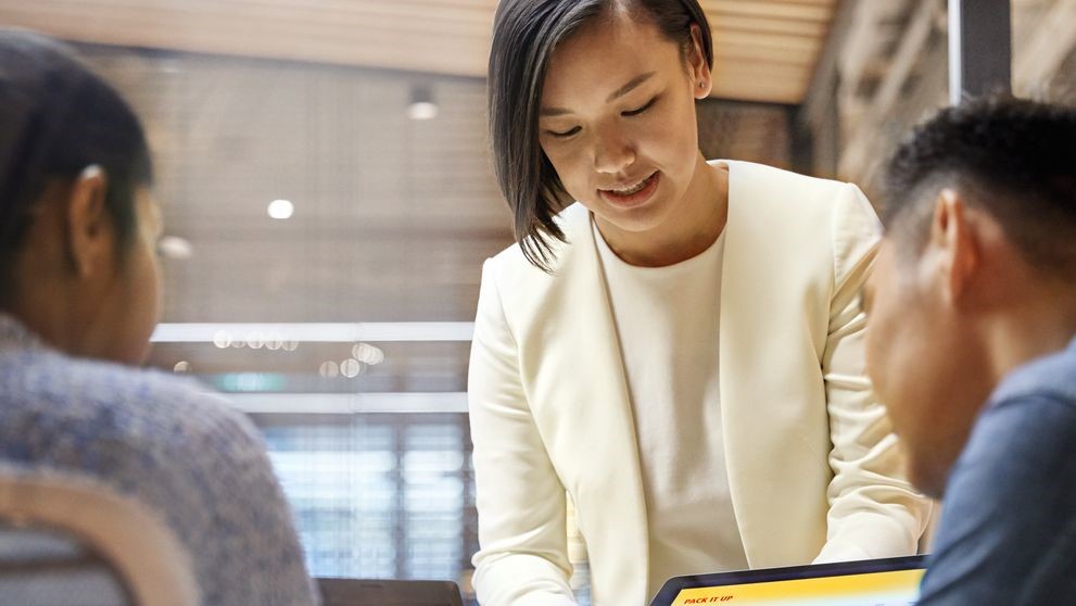 employee showing customers the dhl shipping cost calculator