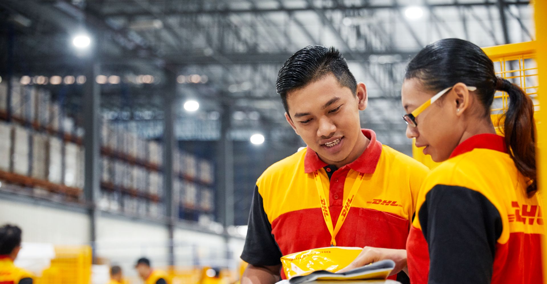 พนักงาน DHL Express จากประเทศไทย 2 คน เตรียมคัดแยกพัสดุเพื่อส่งออก
