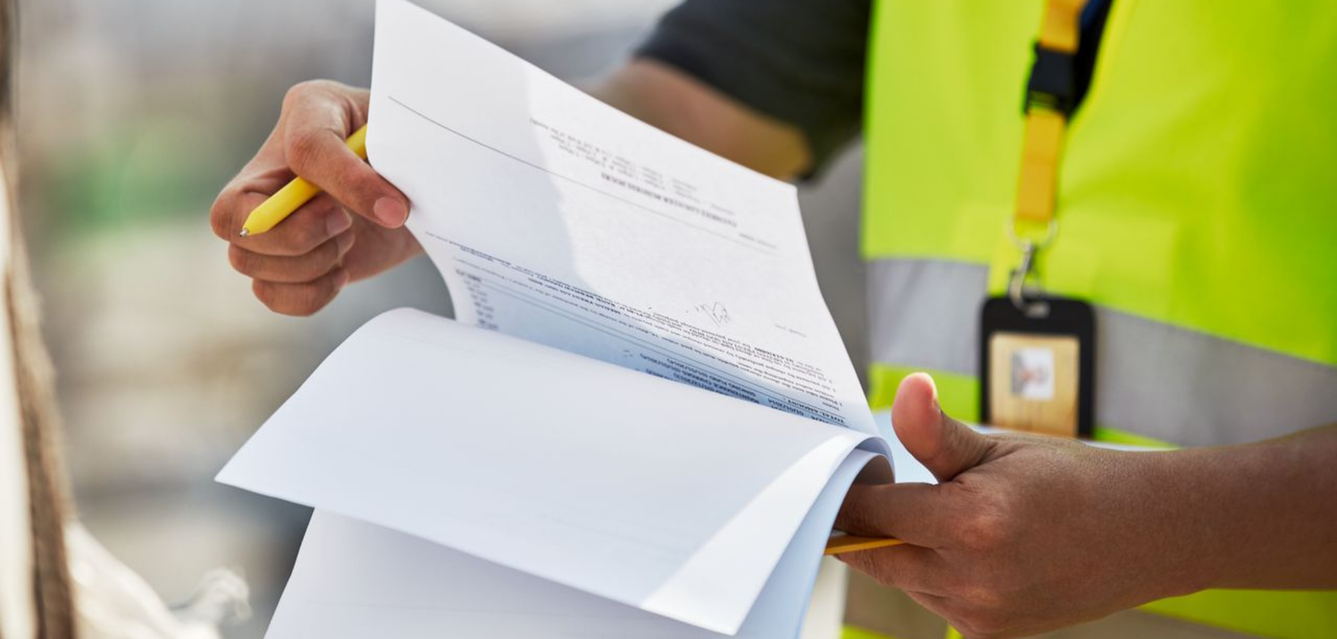 guy wearing reflective vest and holding documents