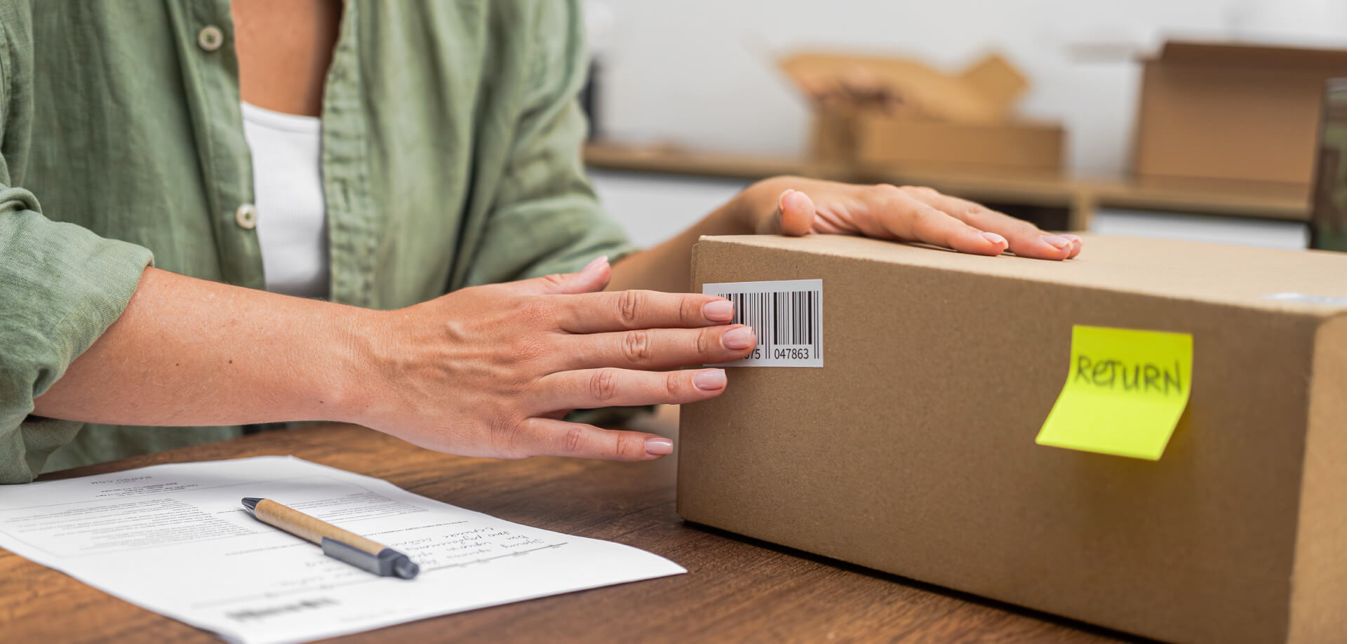 Someone pressing barcode label onto brown box