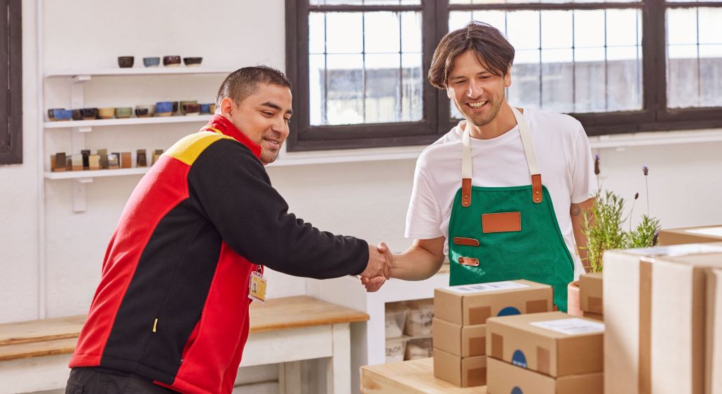 DHL courier shaking hands with small business owner 