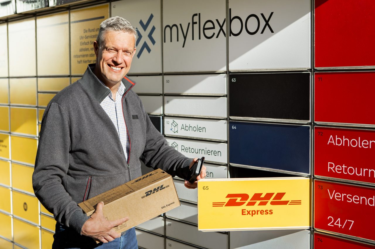 CEO in front of parcel locker with package