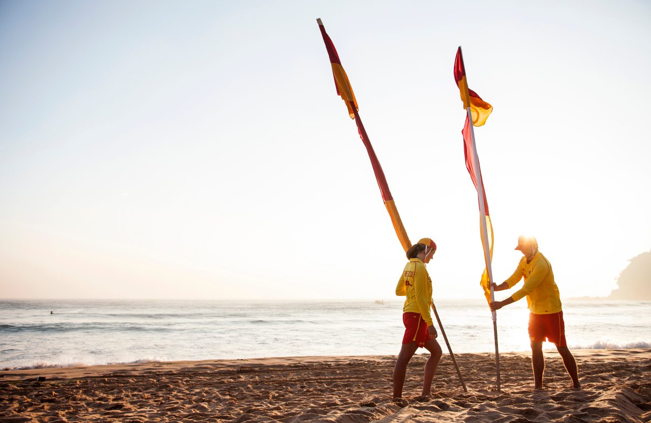 DHL x SLSA staff installing beach safety flags